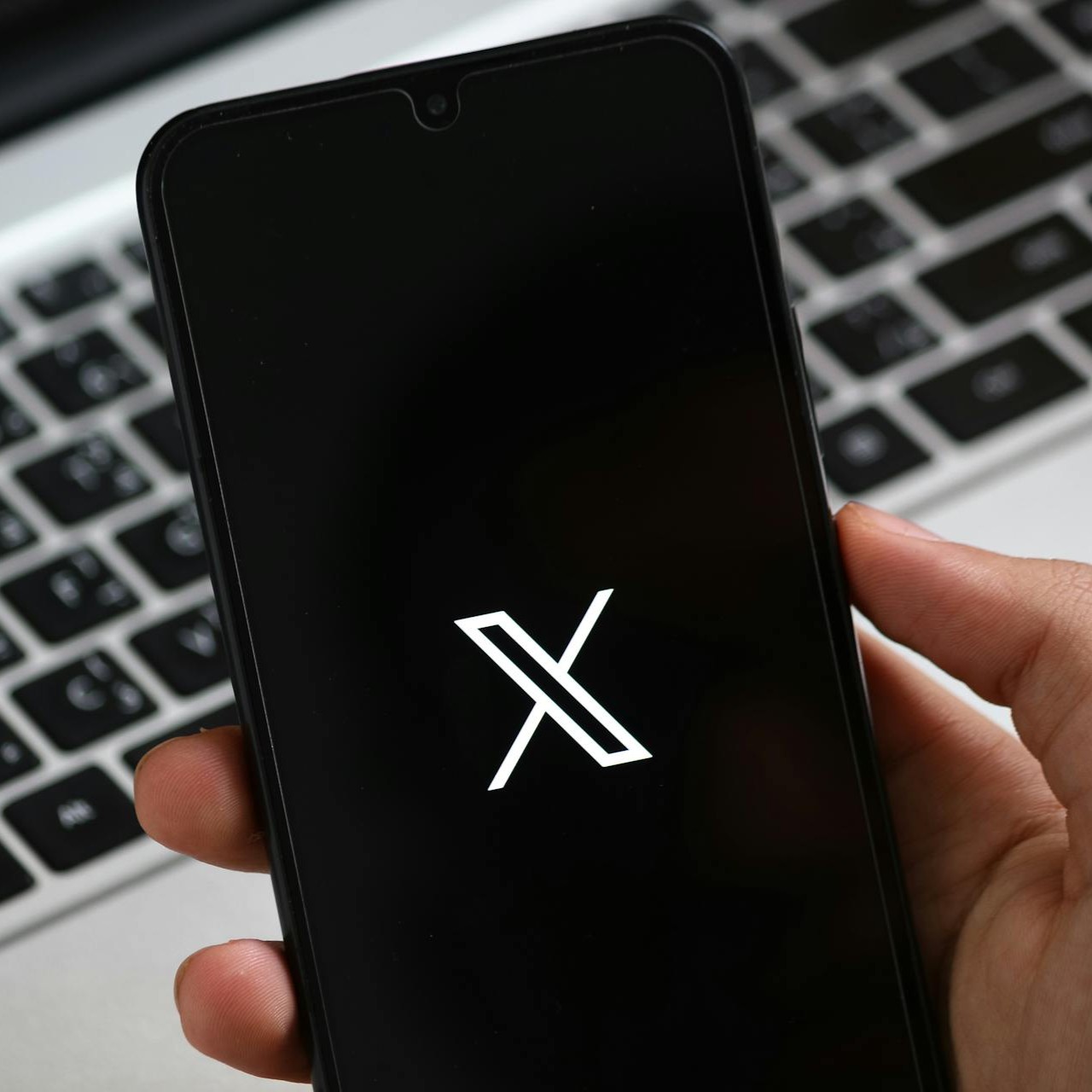 X in hand twitter-background-img-nasirdigital